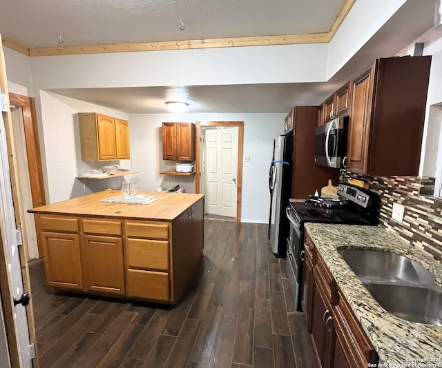 335 E San Antonio St, Marion, TX 78124 - kitchen featuring appliances with stainless steel finishes, dark wood-type flooring, backsplash, and wood counters
