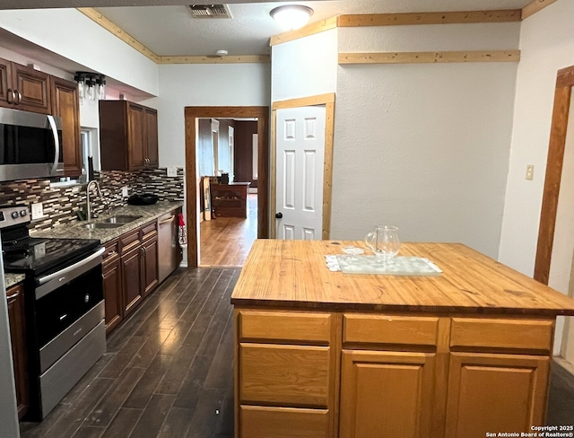 335 E San Antonio St, Marion, TX 78124 - kitchen with appliances with stainless steel finishes, wooden counters, dark wood finished floors, and decorative backsplash