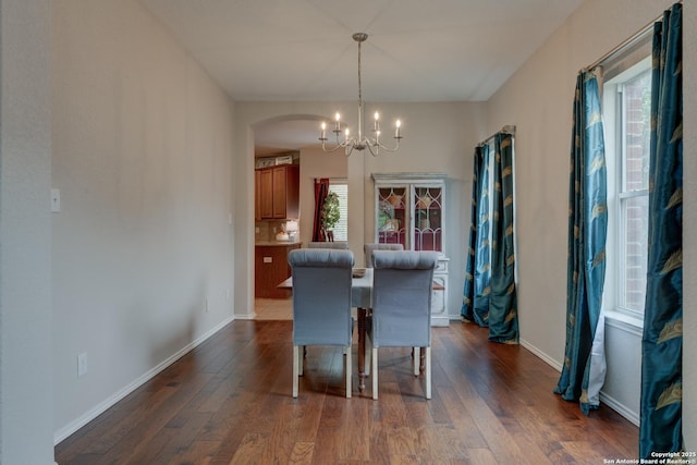 1154 Kite, New Braunfels, TX 78130 - dining room with dark wood-style flooring, plenty of natural light, a chandelier, and arched walkways