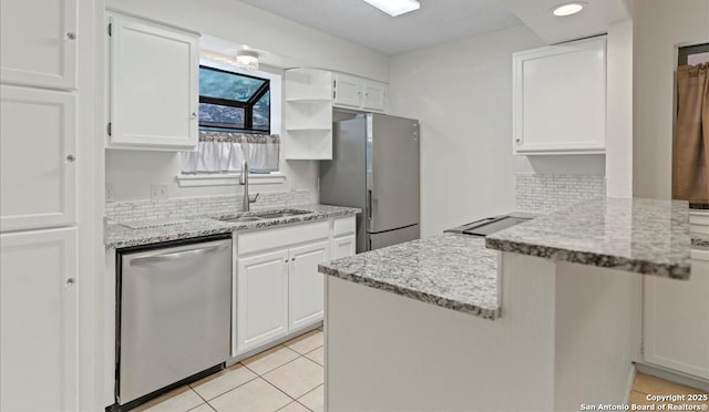 10955 Wurzbach Unit 306, San Antonio, TX 78230 - kitchen with appliances with stainless steel finishes, white cabinetry, a peninsula, light tile patterned floors, and open shelves