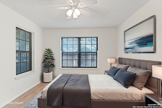 10955 Wurzbach Unit 306, San Antonio, TX 78230 - bedroom with light wood-style floors, multiple windows, and a ceiling fan