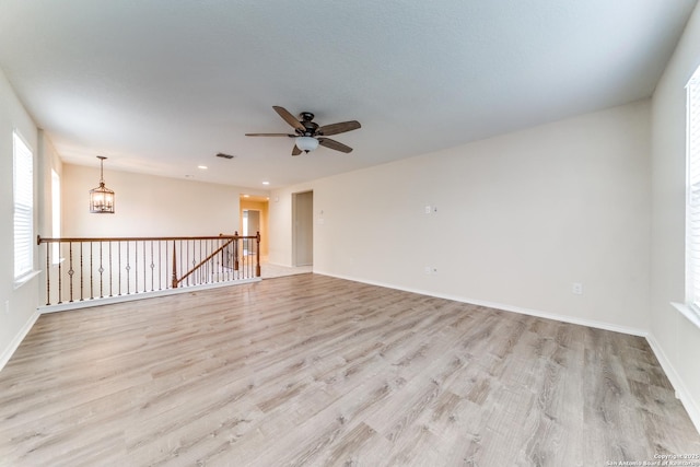 129 Sandy Shl, Boerne, TX 78006 - spare room featuring light wood finished floors, ceiling fan, recessed lighting, and a chandelier