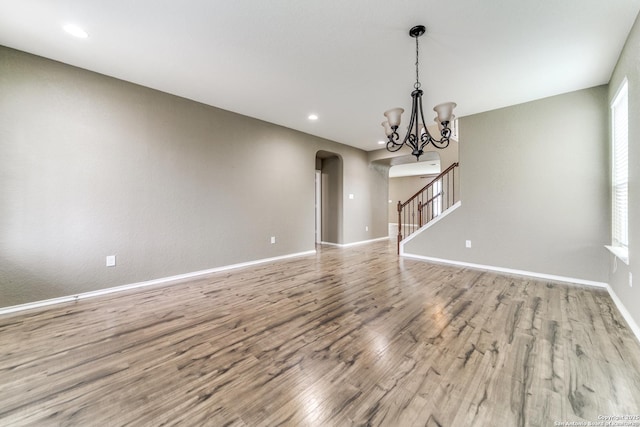 129 Sandy Shl, Boerne, TX 78006 - unfurnished living room featuring arched walkways, wood finished floors, stairs, a chandelier, and recessed lighting