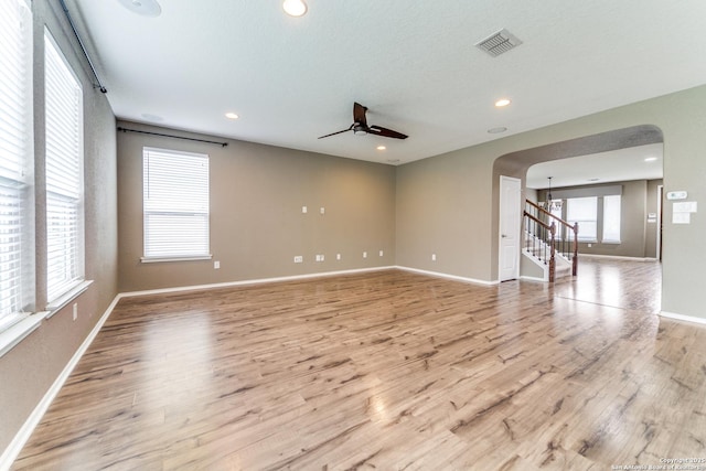 129 Sandy Shl, Boerne, TX 78006 - spare room featuring arched walkways, light wood-type flooring, ceiling fan, stairway, and recessed lighting