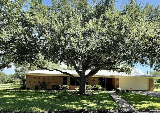 803 Leland, Kenedy, TX 78119 - ranch-style house with a garage, a front yard, and a metal roof