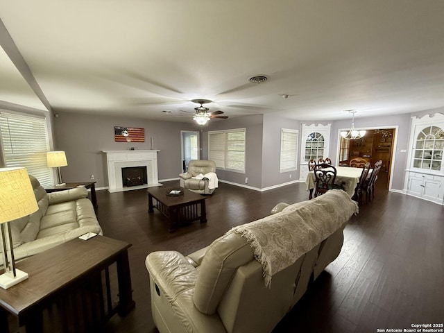 803 Leland, Kenedy, TX 78119 - living room with dark wood-style flooring, a ceiling fan, a fireplace with flush hearth, and a chandelier