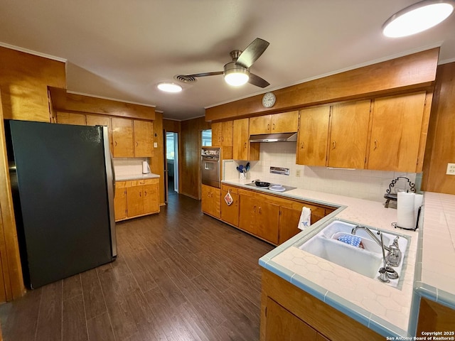 803 Leland, Kenedy, TX 78119 - kitchen featuring appliances with stainless steel finishes, under cabinet range hood, light countertops, ornamental molding, and brown cabinetry
