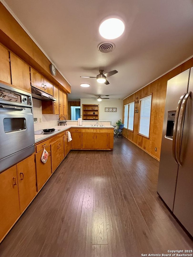 803 Leland, Kenedy, TX 78119 - kitchen with stainless steel appliances, a peninsula, under cabinet range hood, a ceiling fan, and dark wood-style flooring