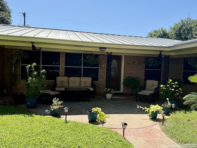 803 Leland, Kenedy, TX 78119 - view of front of house featuring a standing seam roof, a patio area, a metal roof, an outdoor living space, and brick siding