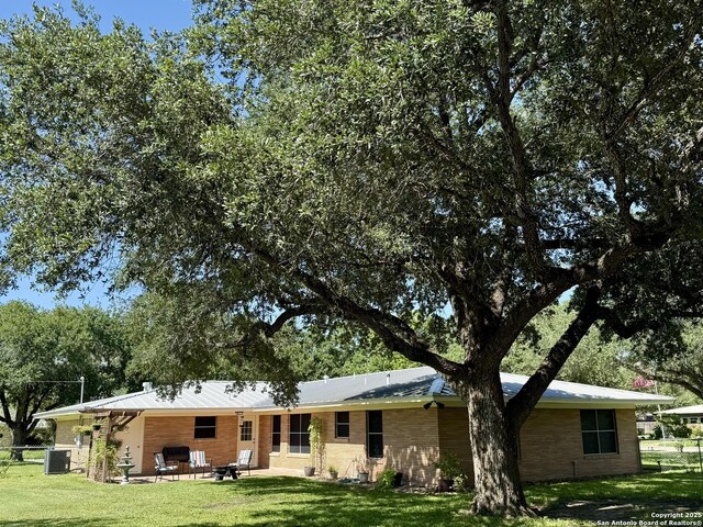 803 Leland, Kenedy, TX 78119 - back of property featuring a yard, a patio, and brick siding