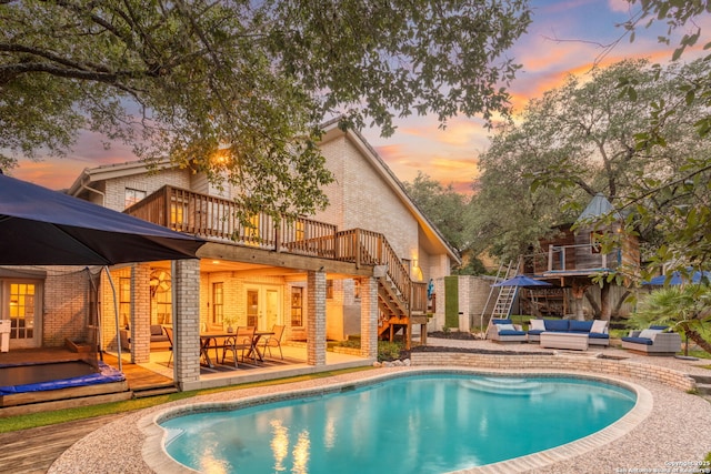 2915 Quail Oak, San Antonio, TX 78232 - pool at dusk featuring outdoor lounge area, a wooden deck, stairway, and an outdoor pool