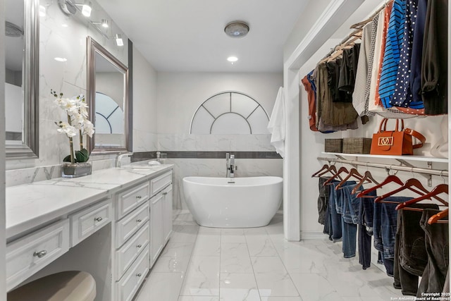 2915 Quail Oak, San Antonio, TX 78232 - bathroom with marble finish floors, double vanity, a soaking tub, tile walls, and a walk in closet