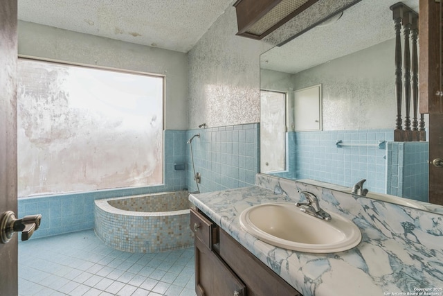 6231 Little Fawn, San Antonio, TX 78238 - full bath with vanity, a bath, tile patterned flooring, a textured ceiling, and tile walls