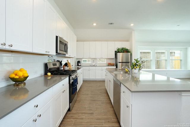 5798 Luciano Trl, Seguin, TX 78155 - kitchen featuring stainless steel appliances, tasteful backsplash, light wood finished floors, recessed lighting, and white cabinets
