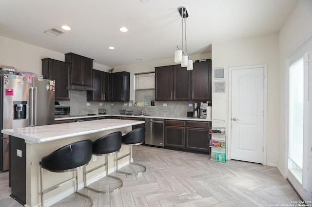 561 Dusty Emerald, Universal City, TX 78148 - kitchen with appliances with stainless steel finishes, decorative backsplash, a center island, recessed lighting, and dark brown cabinets