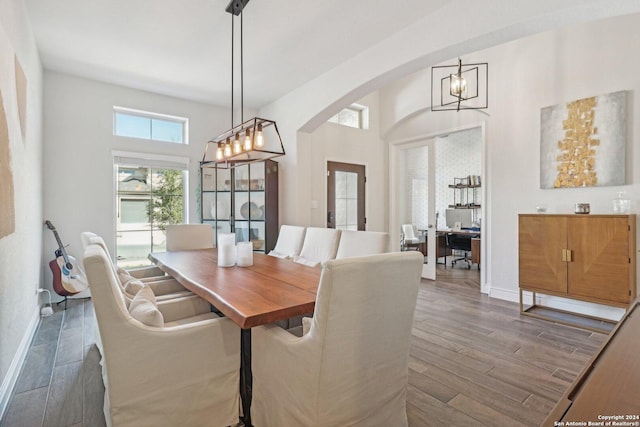 9032 Raven Pointe, San Antonio, TX 78255 - dining room featuring a chandelier, arched walkways, dark wood-style floors, and a towering ceiling