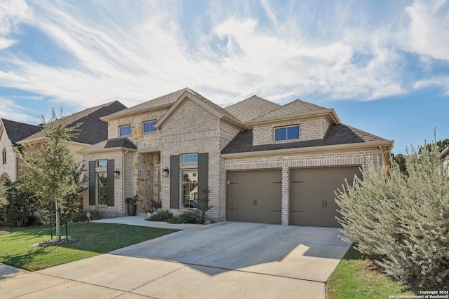 9032 Raven Pointe, San Antonio, TX 78255 - french country inspired facade with concrete driveway, brick siding, an attached garage, a front yard, and roof with shingles