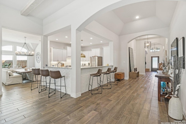 9032 Raven Pointe, San Antonio, TX 78255 - kitchen featuring freestanding refrigerator, a chandelier, a kitchen breakfast bar, plenty of natural light, and a high ceiling