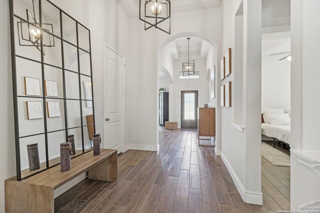9032 Raven Pointe, San Antonio, TX 78255 - entrance foyer featuring arched walkways, a towering ceiling, dark wood-style floors, and a chandelier