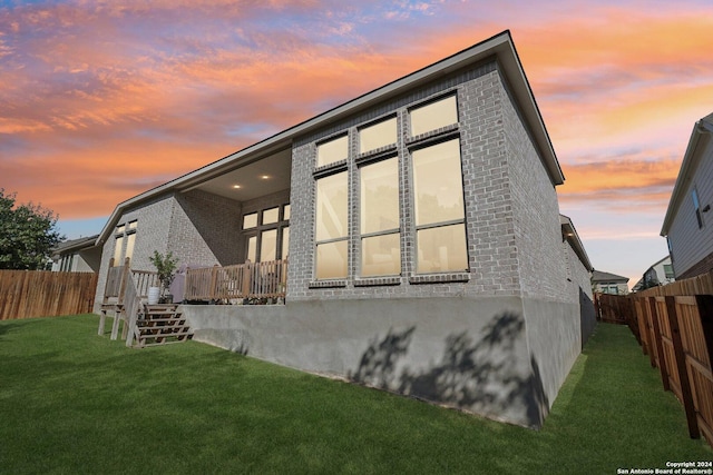9032 Raven Pointe, San Antonio, TX 78255 - back of house at dusk featuring brick siding, a fenced backyard, stairway, and a deck