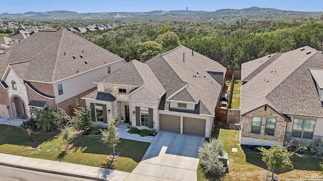 9032 Raven Pointe, San Antonio, TX 78255 - view of front of house featuring stone siding, driveway, and a forest view