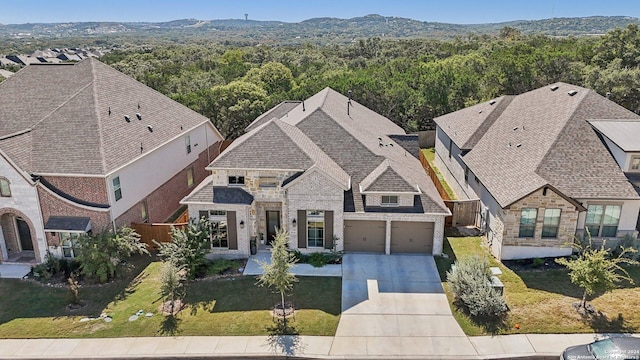 9032 Raven Pointe, San Antonio, TX 78255 - view of front of property featuring concrete driveway, stone siding, and a wooded view