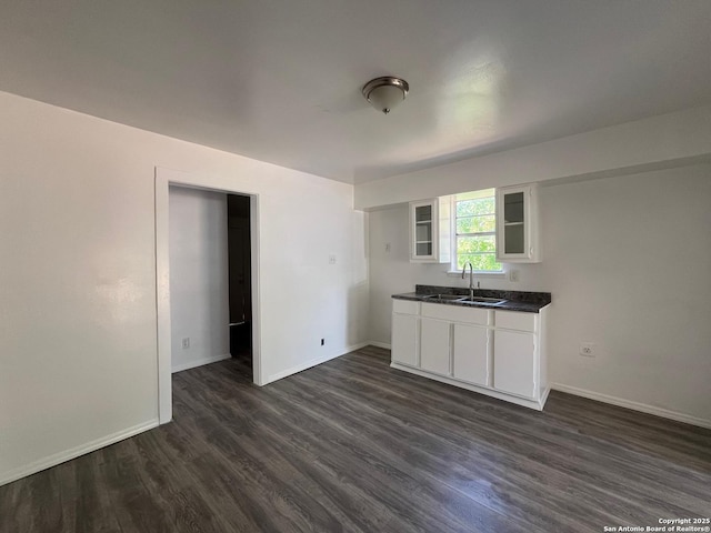 130 N Trevino, Pearsall, TX 78061 - kitchen with dark countertops, dark wood-type flooring, glass insert cabinets, and white cabinetry
