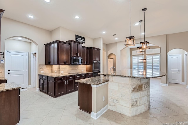3342 Harvest, Marion, TX 78124 - kitchen featuring stainless steel microwave, arched walkways, decorative backsplash, light tile patterned floors, and stone counters