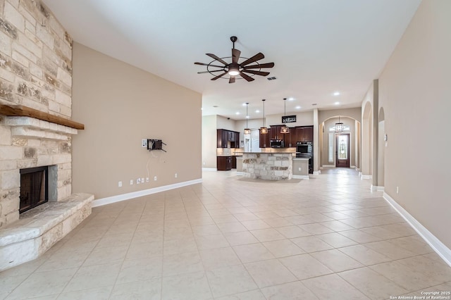 3342 Harvest, Marion, TX 78124 - unfurnished living room featuring arched walkways, ceiling fan, light tile patterned floors, a fireplace, and recessed lighting