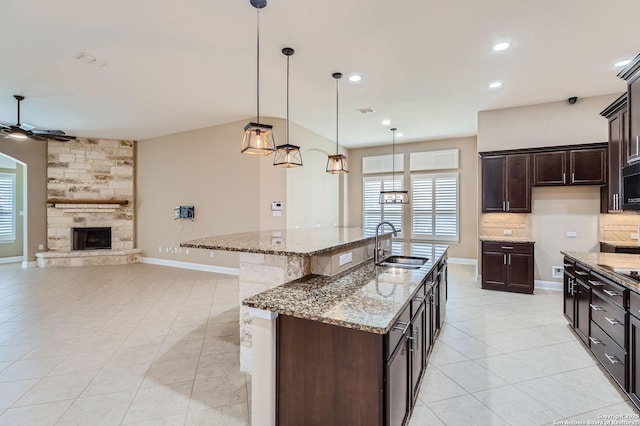 3342 Harvest, Marion, TX 78124 - kitchen with light tile patterned floors, a ceiling fan, decorative backsplash, open floor plan, and light stone counters