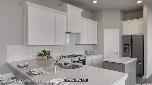 225 Alpine Lks, New Braunfels, TX 78130 - kitchen featuring appliances with stainless steel finishes, light countertops, white cabinets, a peninsula, and decorative backsplash