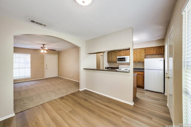 7334 Cherry Brk, San Antonio, TX 78238 - kitchen with white appliances, dark countertops, ceiling fan, light wood-type flooring, and arched walkways