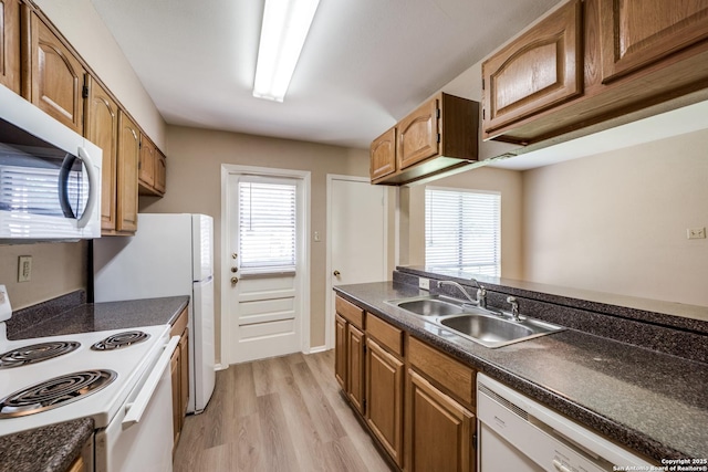 7334 Cherry Brk, San Antonio, TX 78238 - kitchen with white appliances, dark countertops, light wood finished floors, and brown cabinetry