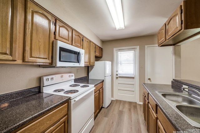 7334 Cherry Brk, San Antonio, TX 78238 - kitchen with white appliances, light wood-type flooring, and brown cabinetry