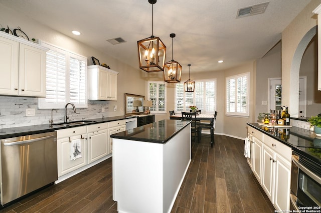 21539 Bubbling Crk, San Antonio, TX 78259 - kitchen featuring appliances with stainless steel finishes, dark wood finished floors, white cabinetry, a kitchen island, and backsplash