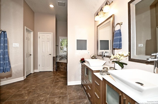 21539 Bubbling Crk, San Antonio, TX 78259 - bathroom featuring double vanity, tiled tub, and a textured ceiling