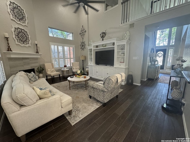 21539 Bubbling Crk, San Antonio, TX 78259 - living room with ceiling fan, dark wood-style floors, a high ceiling, and a tiled fireplace