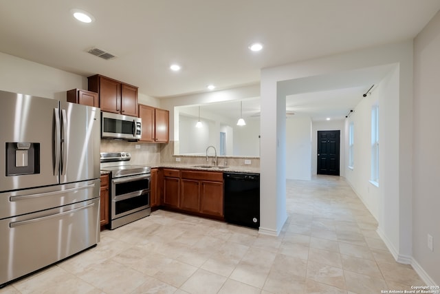 8438 Cordova Pt, San Antonio, TX 78252 - kitchen featuring appliances with stainless steel finishes, backsplash, light tile patterned floors, recessed lighting, and brown cabinetry
