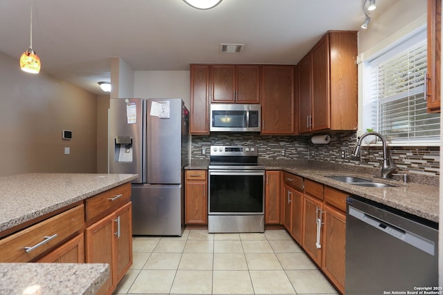 5124 Knollwood, Schertz, TX 78108 - kitchen featuring stainless steel appliances, backsplash, light tile patterned floors, light stone counters, and brown cabinets