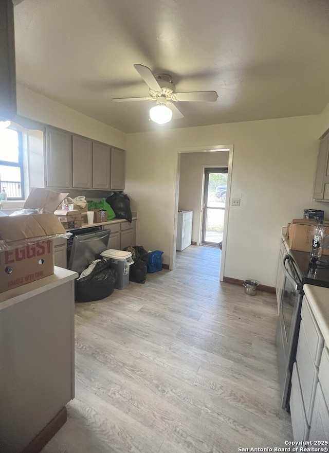 179 Cherry Springs Rd, Hunt, TX 78024 - kitchen with stainless steel range with electric stovetop, gray cabinetry, light wood-style floors, a ceiling fan, and washer / clothes dryer