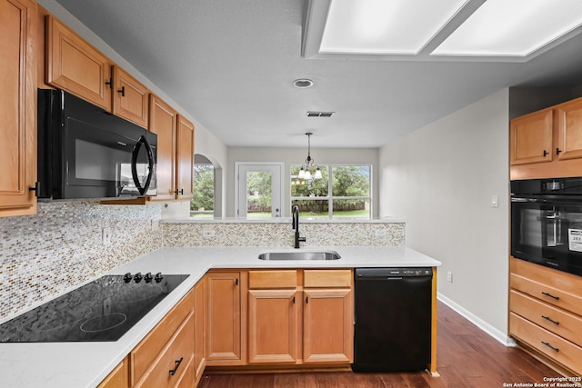 29732 Cojak Cir, Boerne, TX 78015 - kitchen with black appliances, dark wood-style flooring, tasteful backsplash, light countertops, and hanging light fixtures