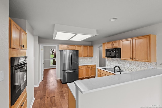 29732 Cojak Cir, Boerne, TX 78015 - kitchen with black appliances, backsplash, wood finished floors, light countertops, and a peninsula