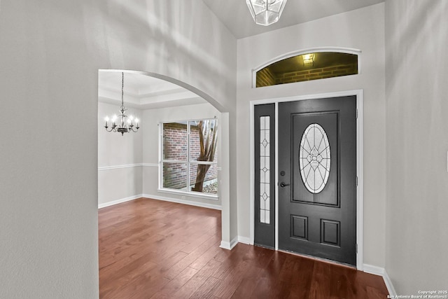 29732 Cojak Cir, Boerne, TX 78015 - entrance foyer featuring a chandelier, dark wood-style floors, and arched walkways