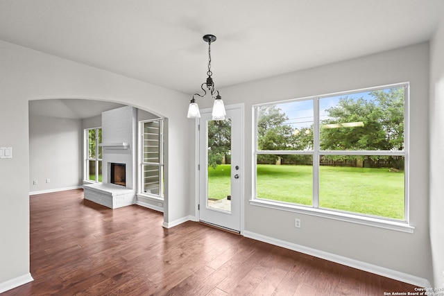 29732 Cojak Cir, Boerne, TX 78015 - unfurnished dining area featuring a fireplace, dark wood-style floors, and healthy amount of natural light