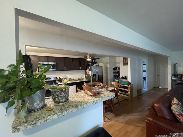 203 Galway, San Antonio, TX 78223 - kitchen featuring appliances with stainless steel finishes, open floor plan, dark brown cabinets, light countertops, and a ceiling fan