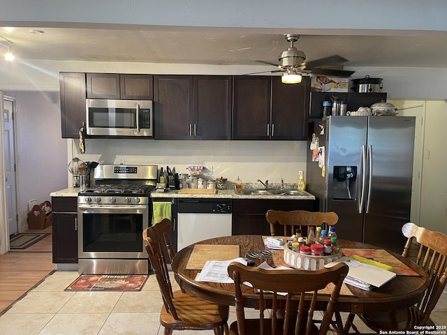 203 Galway, San Antonio, TX 78223 - kitchen with appliances with stainless steel finishes, ceiling fan, dark brown cabinetry, and light tile patterned floors