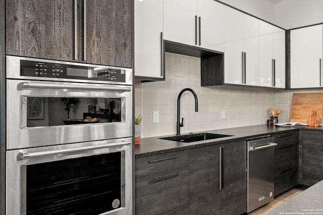 238 Cassiano St, San Antonio, TX 78204 - kitchen featuring stainless steel appliances, white cabinetry, decorative backsplash, modern cabinets, and light wood-style flooring