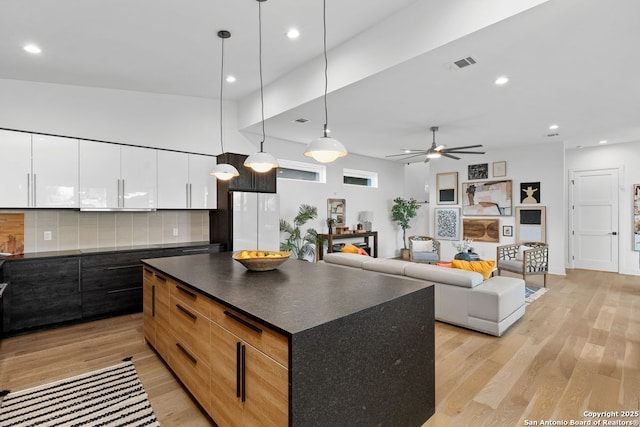238 Cassiano St, San Antonio, TX 78204 - kitchen featuring dark countertops, ceiling fan, light wood-style floors, modern cabinets, and decorative backsplash