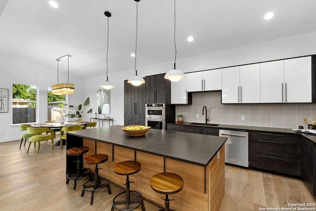 238 Cassiano St, San Antonio, TX 78204 - kitchen featuring appliances with stainless steel finishes, dark countertops, backsplash, light wood-style flooring, and recessed lighting