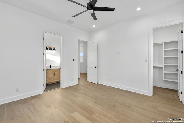 238 Cassiano St, San Antonio, TX 78204 - unfurnished bedroom with light wood finished floors, a walk in closet, recessed lighting, ensuite bath, and ceiling fan